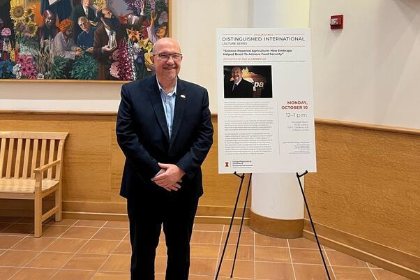 Guy de Capdeville, Embrapa’s executive director of research and development stands by the poster advertising his lecture.