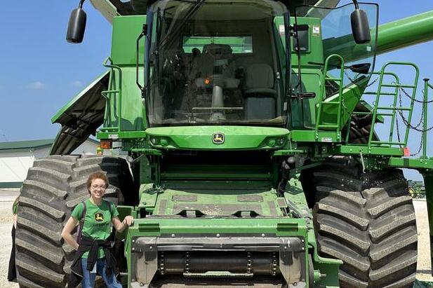Jarai Carter poses for a picture next too a large tractor