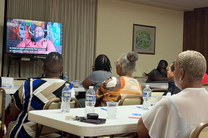 Event attendees watch a screening of the video about Iota Phi Theta Fraternity