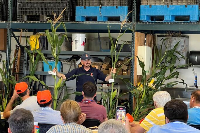 Tony Studer, Crop Sciences, shows corn with two diffferent leaf areas.  