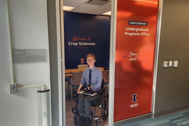 A man in a wheelchair smiles in the doorway of the new study space
