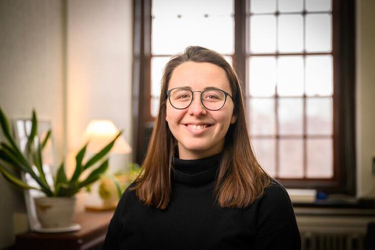 Maria Kalaitzandonakes smiles at the viewer in a warmly lit office setting.