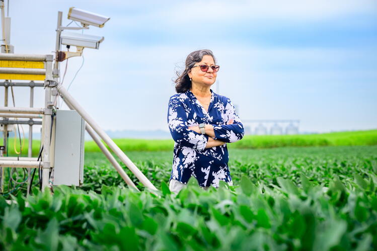 Madhu Khanna poses by research equipment in a field