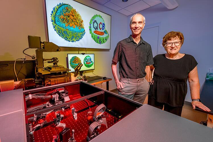 Two people standing in front of laboratory equipment