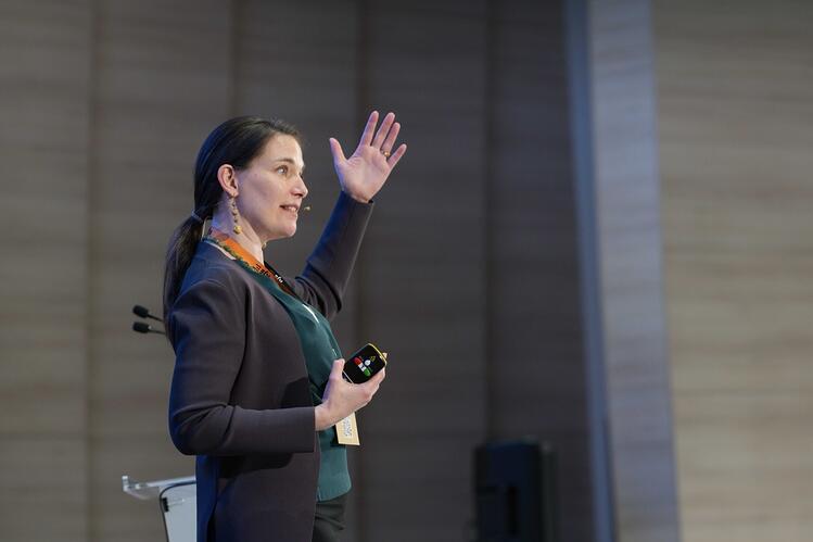 Women speaking and holding arm in the air