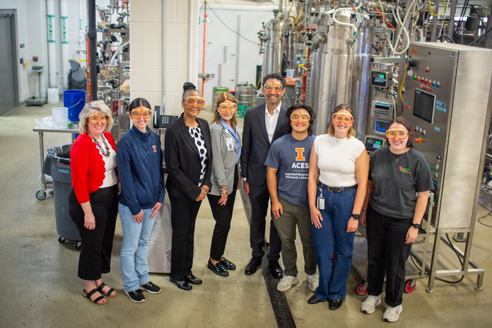 Representatives wear goggles and line up for a photo