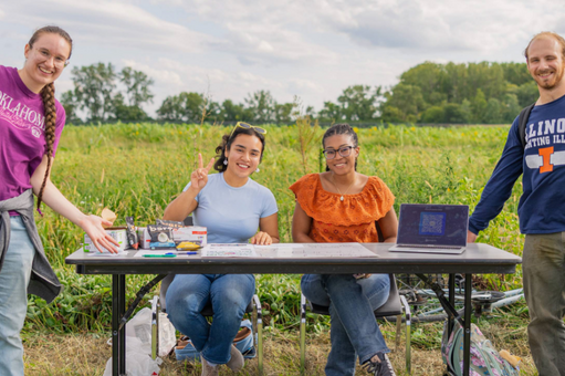 Students pose at a table outside