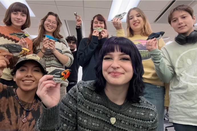 Students pose with painted bird toys.