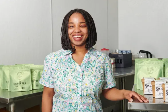 Angelica Lee stands beside her tea products. 