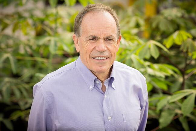 A man in a dress shirt standing in front of a field