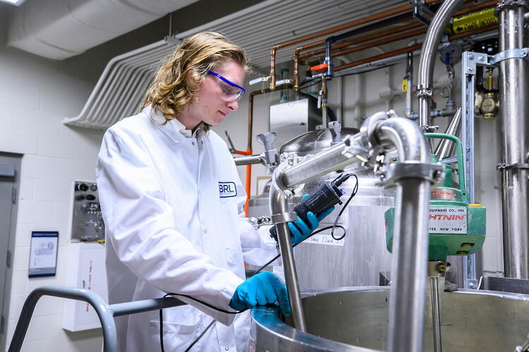 A man in a lab coat works with instruments in a precision fermentation laboratory