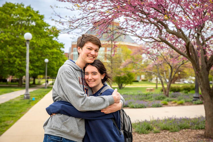 A young man and a young woman embracing on the University of Illinois quad