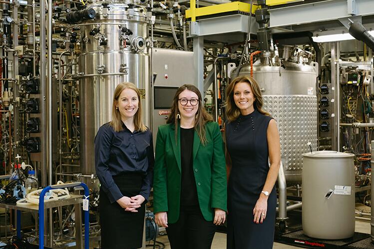 Beth Conerty, Carly McCrory-McKay, and Nicole Bateman (L-R) stand in front of equipment at the IBRL.