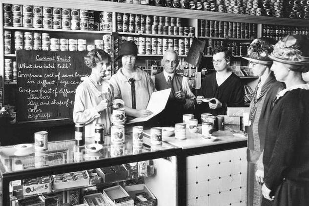 Historical photo of women around a table with grocery items