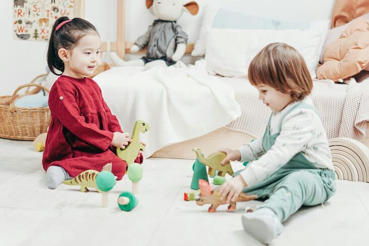 Two children play with dinosaur toys together
