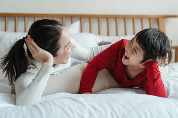 A mother and her young son laugh together