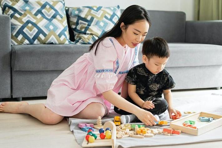 A mother and her son play with blocks together