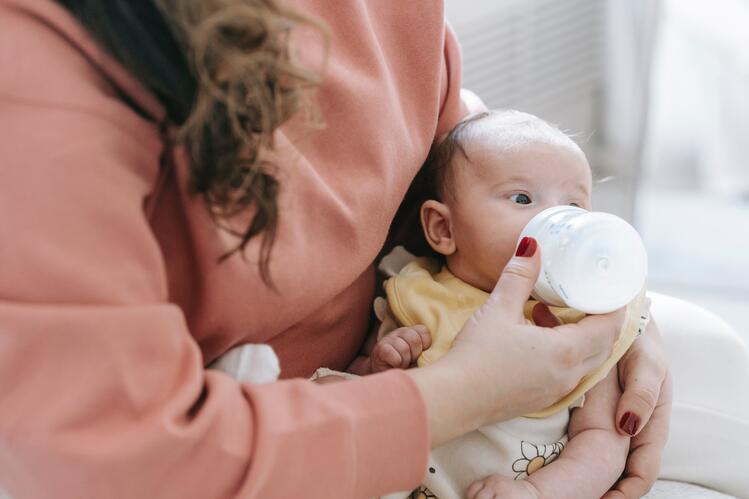 Mother with infant bottle feeding
