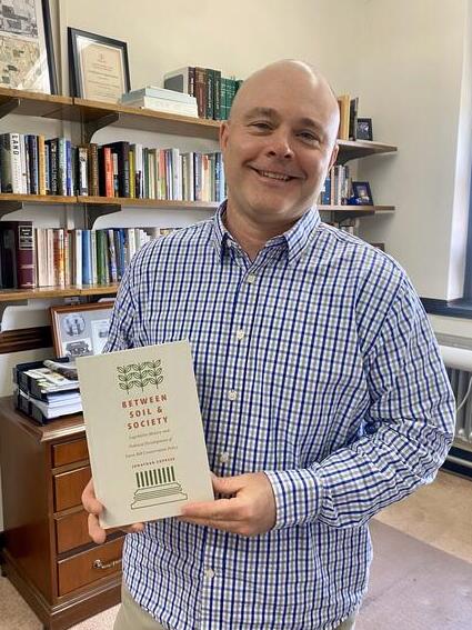 Jonathan Coppess poses with copy of book