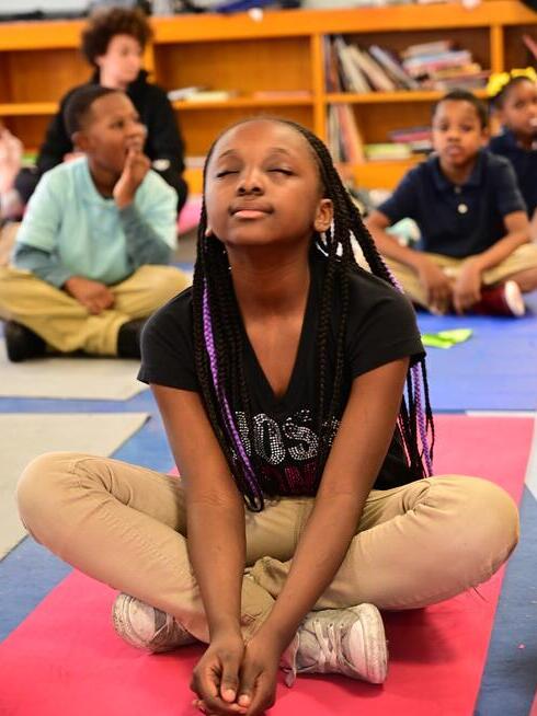 Students participate in mindfulness exercises. Photo courtesy of Holistic Life Foundation. chlid meditating