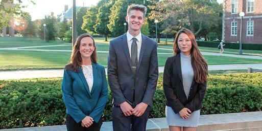 Three students standing by the south quad