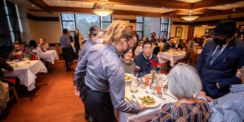 Student serving dinner at the Spicebox restaraunt.