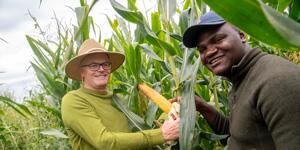 Students holding corn crops.